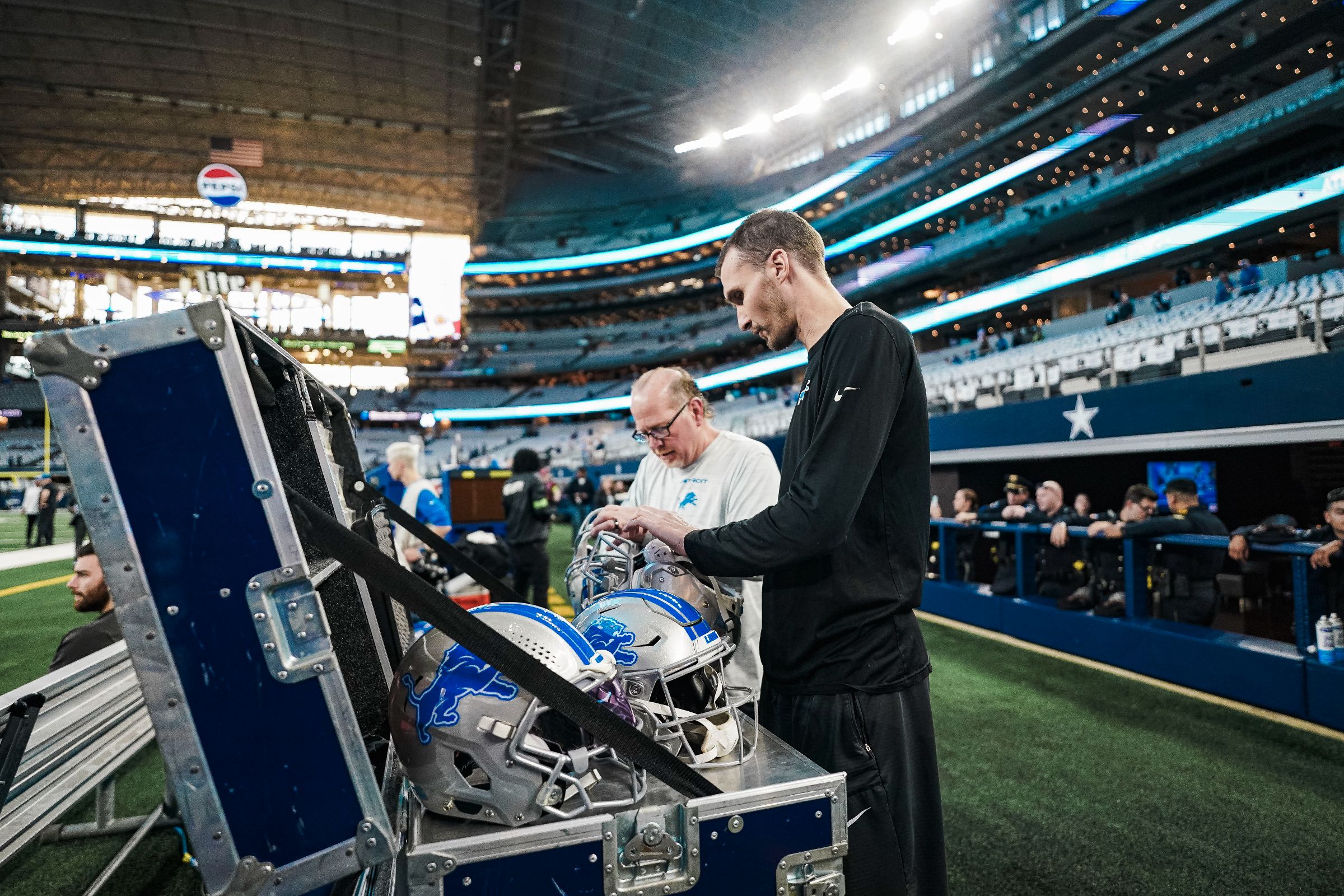 Tim O'Neill and Joey Jaroshewich work on the sidelines of a Lions game